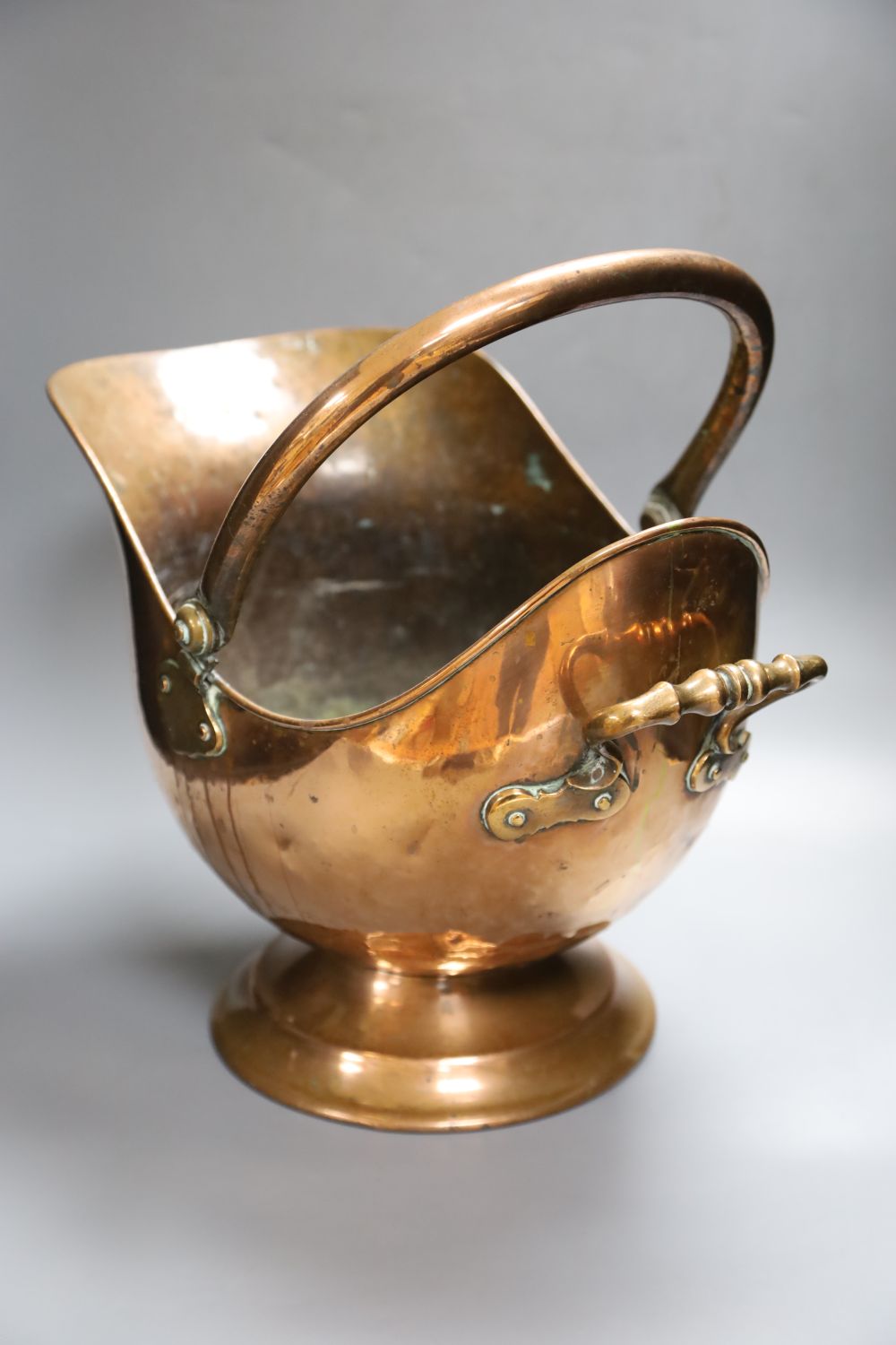 A 19th century planished copper helmet coal scuttle